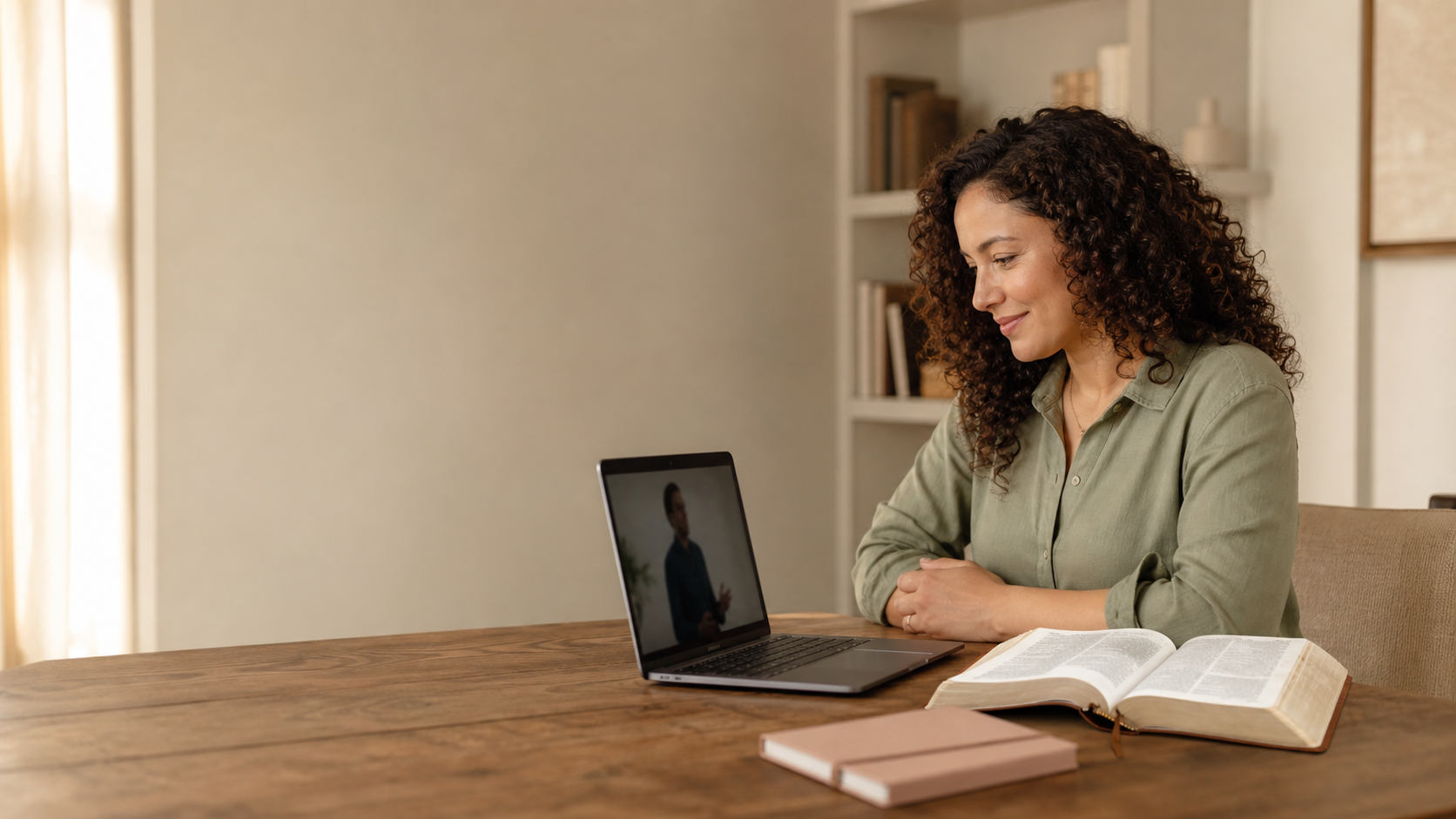 A woman watching a video devotional beside an open Bible